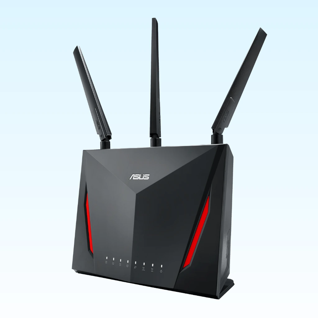 A black ASUS RT-AC86U router with red accents and three external antennas, positioned against a light blue background.