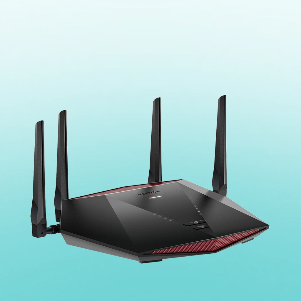 A Netgear Nighthawk XR1000 with red accents and four external antennas, positioned against a light blue background.